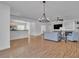 Spacious living room featuring an open floor plan, hardwood floors, modern lighting, and lots of seating at 11253 Revelry Ln, Las Vegas, NV 89138