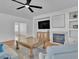 Cozy living room featuring hardwood floors, modern decor, a ceiling fan, and a beautiful fireplace at 11253 Revelry Ln, Las Vegas, NV 89138