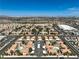 Wide aerial view of a community with pools, carports, lush greenery, and city views in the background at 1201 N Buffalo Dr # 202, Las Vegas, NV 89128