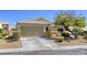 Single-story home with xeriscaped front yard, covered entry, and two-car garage at 1208 Neva Ranch Ave, North Las Vegas, NV 89081