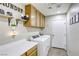 Functional laundry room with modern appliances, overhead cabinets, and decorative shelving at 1208 Neva Ranch Ave, North Las Vegas, NV 89081
