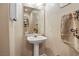 Close-up of a powder room featuring a pedestal sink, mirror, and decorative accents at 2366 Brockton Way, Henderson, NV 89074