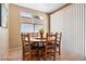 Cozy dining area with a wooden table and chairs, illuminated by natural light from a window at 2366 Brockton Way, Henderson, NV 89074
