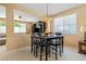 Cozy dining area with dark wood table and chairs, illuminated by an elegant chandelier, adjacent to living space at 2366 Brockton Way, Henderson, NV 89074