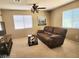 Cozy living room featuring a plush brown sofa and a ceiling fan with decorative lighting at 2366 Brockton Way, Henderson, NV 89074