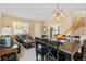 Open-concept living and dining areas feature a comfortable sofa, dining table and staircase to upper level at 2366 Brockton Way, Henderson, NV 89074