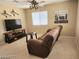 Comfortable living room featuring a plush couch, ceiling fan, and window bringing in natural light at 2366 Brockton Way, Henderson, NV 89074
