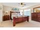 Comfortable main bedroom with neutral carpet, wood furniture and triple windows at 2366 Brockton Way, Henderson, NV 89074