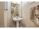 A modern powder room with a pedestal sink, framed mirror, and decorative elements at 2366 Brockton Way, Henderson, NV 89074