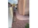 View of the side yard, with a gravel bed and walkway between two walls at 2366 Brockton Way, Henderson, NV 89074