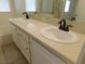 Bathroom vanity featuring dual sinks, white cabinetry, and bronze fixtures under a large mirror at 241 Honeywood St, Henderson, NV 89074
