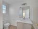 Bright bathroom showcasing a toilet, modern vanity with a white countertop, and natural light from a window at 2431 Lilac Cove St, Las Vegas, NV 89135