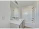 Bright bathroom with white tiled shower over tub, a mirror, and a modern vanity with a white countertop at 2431 Lilac Cove St, Las Vegas, NV 89135