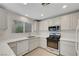 Bright kitchen features modern appliances, white cabinets, and light countertops at 2431 Lilac Cove St, Las Vegas, NV 89135