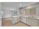 Open kitchen with stainless steel sink, white cabinets and countertops overlooking a dining and patio area at 2431 Lilac Cove St, Las Vegas, NV 89135