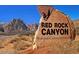 Sign at Red Rock Canyon National Conservation Area in Nevada with distant mountains under a blue sky at 2431 Lilac Cove St, Las Vegas, NV 89135