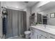 Modern bathroom with bright vanity, stainless steel fixtures, and shower with decorative curtain at 2530 Catallo St, Henderson, NV 89044