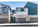 Modern townhome featuring attached garage, front yard landscaping, and sleek architectural details at 2530 Catallo St, Henderson, NV 89044