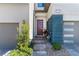 Inviting front entrance with a modern door, gray and blue facade, and well-manicured landscaping at 2530 Catallo St, Henderson, NV 89044