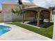 Beautiful backyard oasis with pool, outdoor shower, pergola with hanging chair, and artificial turf at 332 Dockside Ct, Las Vegas, NV 89145