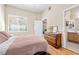 Comfortable bedroom featuring hardwood floors, a dark wood dresser, and a large window for ample natural light at 3451 Desert Cliff St # 103, Las Vegas, NV 89129
