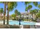 Enjoy this spacious community pool with palm trees, lounge chairs and tables, and nearby parking for easy access at 3451 Desert Cliff St # 103, Las Vegas, NV 89129