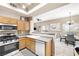 Kitchen with a stove, microwave, wood cabinets, countertops, and open to the living and dining areas at 3451 Desert Cliff St # 103, Las Vegas, NV 89129