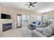 Comfortable living room featuring a fireplace, large windows, and plush seating with a glimpse of the dining area at 3451 Desert Cliff St # 103, Las Vegas, NV 89129