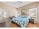 Comfortable main bedroom with ceiling fan, desk and chair and warm neutral walls with a vibrant painting at 3451 Desert Cliff St # 103, Las Vegas, NV 89129