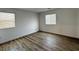This bedroom features natural light from two windows and durable wood laminate flooring at 3493 Arcadian King Ave, Las Vegas, NV 89106