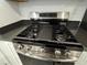 Close-up of the stainless steel gas range with black grates and white cabinetry at 3493 Arcadian King Ave, Las Vegas, NV 89106