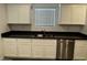 Modern kitchen featuring white cabinets, stainless steel appliances, and dark countertops at 3493 Arcadian King Ave, Las Vegas, NV 89106
