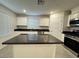 Bright kitchen boasts an island with dark countertops and stainless steel appliances at 3493 Arcadian King Ave, Las Vegas, NV 89106