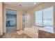 This primary bathroom shows a separate glass shower and a soaking tub with a large window at 4016 Gaster Ave, North Las Vegas, NV 89081