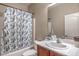 This bathroom features a vanity with a sink and a shower tub combo with a shell patterned curtain at 4016 Gaster Ave, North Las Vegas, NV 89081