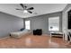 Bedroom with wood floors, a ceiling fan, gray walls, and two windows for natural light at 4215 Macadamia Dr, Las Vegas, NV 89115