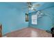 A cozy bedroom featuring vibrant blue walls, a ceiling fan, and ample natural light at 4215 Macadamia Dr, Las Vegas, NV 89115