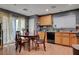 A kitchen with wooden cabinets, appliances, table, and sliding glass doors allowing for natural light at 4215 Macadamia Dr, Las Vegas, NV 89115