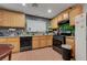 A kitchen with wood cabinets, black appliances, countertops, and a view to the dining area at 4215 Macadamia Dr, Las Vegas, NV 89115