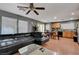 Open concept living and kitchen area features a leather sofa and wood-look floors at 4215 Macadamia Dr, Las Vegas, NV 89115