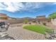 Landscaped backyard features low-maintenance gravel, brick patio, and a patch of artificial turf at 4332 Stardusk Falls Ave, North Las Vegas, NV 89084