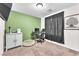 Carpeted bedroom features a large window, a desk area, and a playful green accent wall with decor at 4332 Stardusk Falls Ave, North Las Vegas, NV 89084