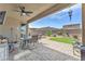 This covered patio features a ceiling fan, table and chairs, and view of the landscaped backyard at 4332 Stardusk Falls Ave, North Las Vegas, NV 89084
