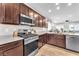 Modern kitchen featuring stainless steel appliances, granite countertops, and ample dark wood cabinet space at 4332 Stardusk Falls Ave, North Las Vegas, NV 89084