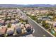 Scenic aerial shot displaying suburban homes along a landscaped road with mountain backdrop at 4512 Long Horse Ct, Las Vegas, NV 89147