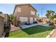 Spacious backyard with patio seating, artificial grass lawn, and partial fence for privacy at 4512 Long Horse Ct, Las Vegas, NV 89147