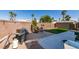 Fenced backyard with a patio, artificial turf, dining table, and a barbeque grill at 4512 Long Horse Ct, Las Vegas, NV 89147