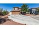 Two-story home features a circular driveway, two-car garage and desert landscaping at 4512 Long Horse Ct, Las Vegas, NV 89147