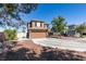 Two-story home features a circular driveway, two-car garage and desert landscaping at 4512 Long Horse Ct, Las Vegas, NV 89147
