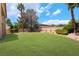Expansive backyard featuring lush green lawn, mature trees, and perimeter landscaping at 5225 Sandy Cactus Ln, Las Vegas, NV 89149